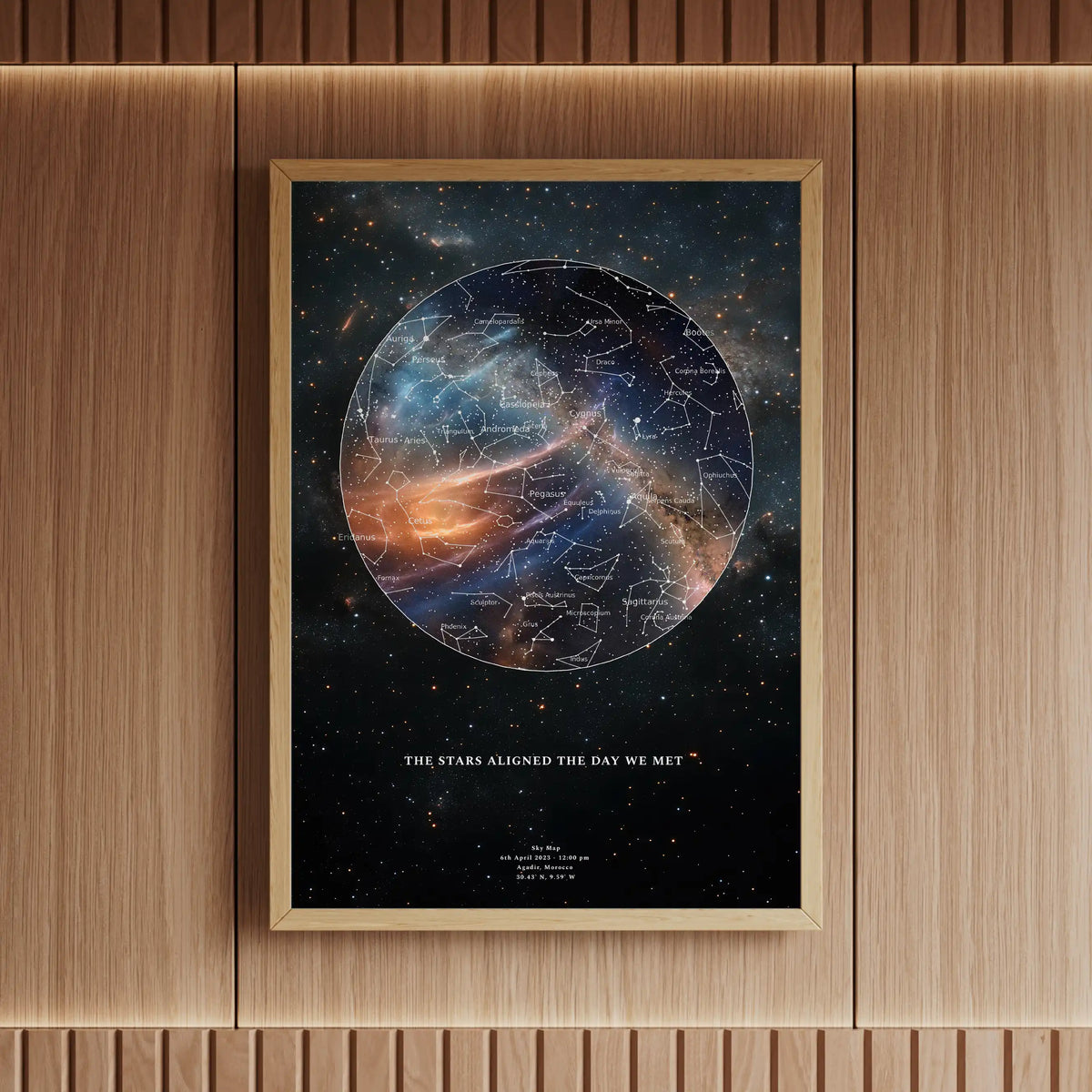 Framed personalised star map print featuring a vibrant galaxy design with detailed constellations, elegantly displayed in a wooden interior with warm lighting.
