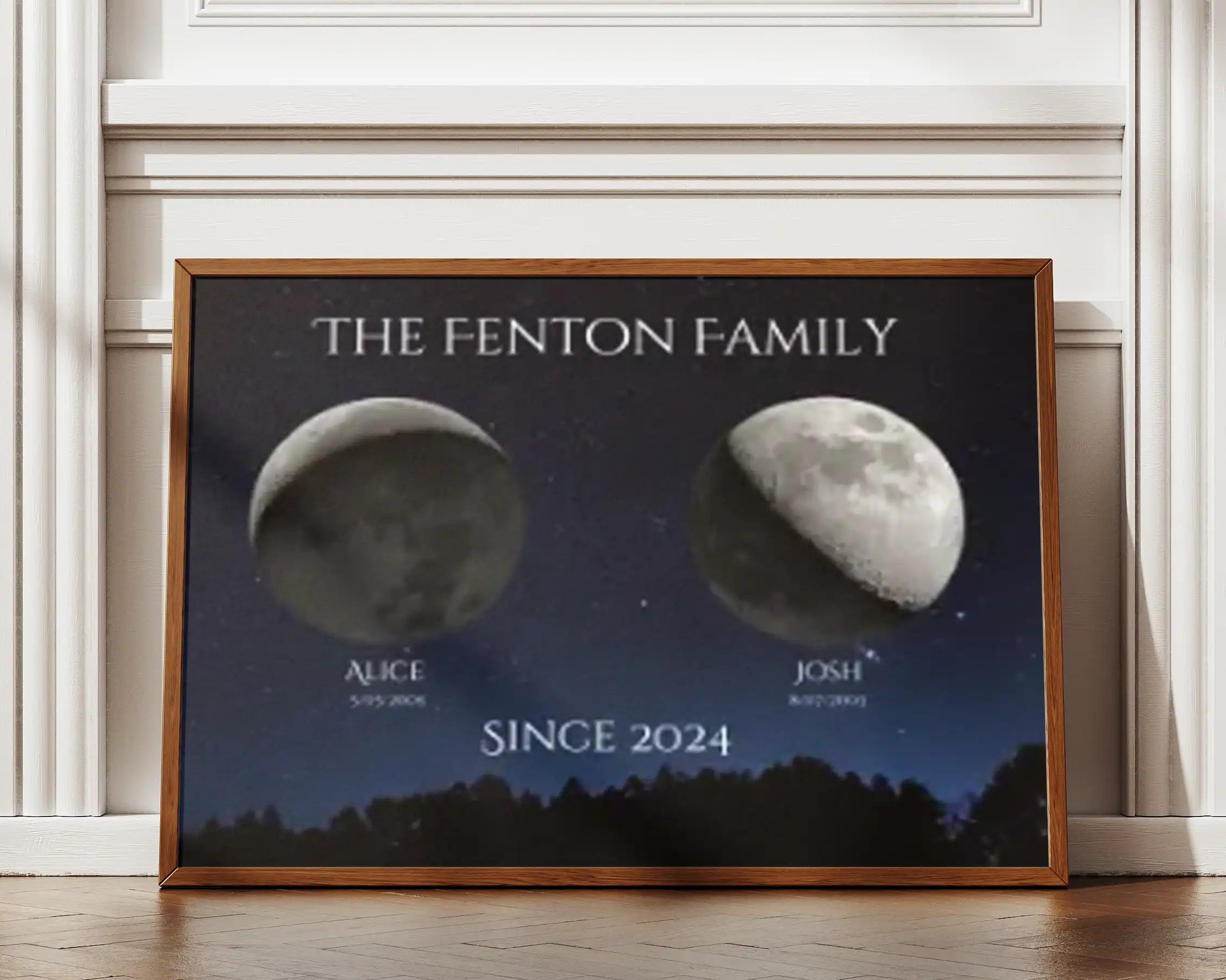 Framed horizontal moon phase print showing two personalised lunar phases with names and birth dates under a starry sky, titled ‘The Fenton Family – Since 2024’, by Skylit Studio.