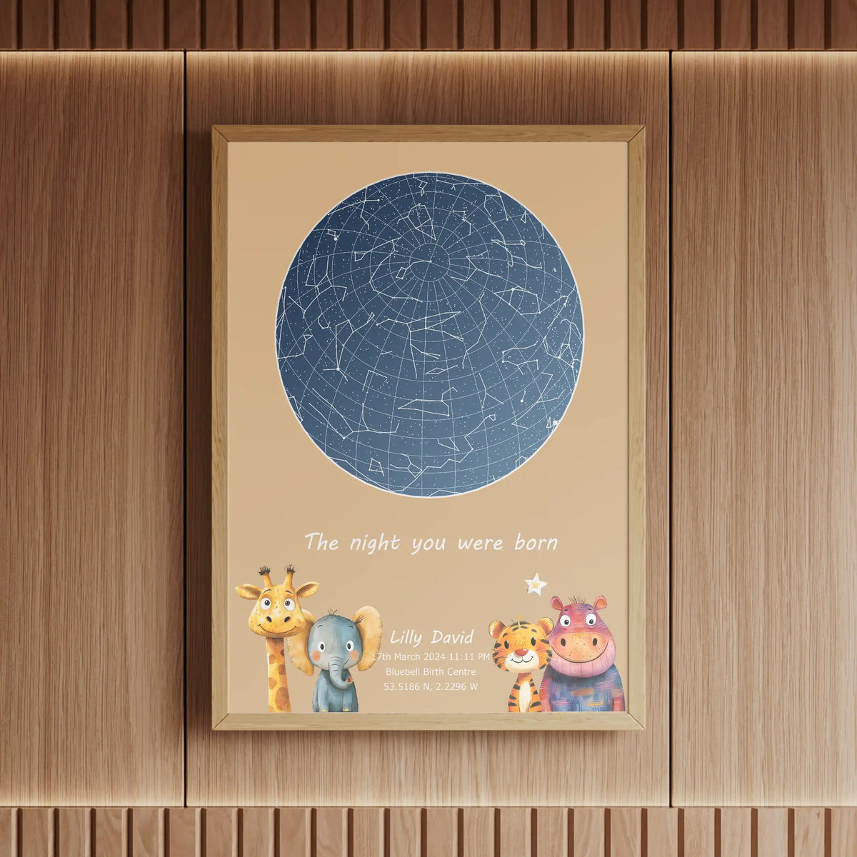 Framed personalised star map print for a child's birth, featuring a blue constellation design on a beige background with illustrated animal characters, displayed in a wooden setting with warm lighting.