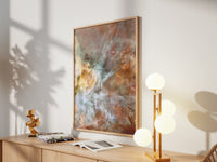 Framed Carina Nebula print by Skylit Studio on a sideboard in a bright living room