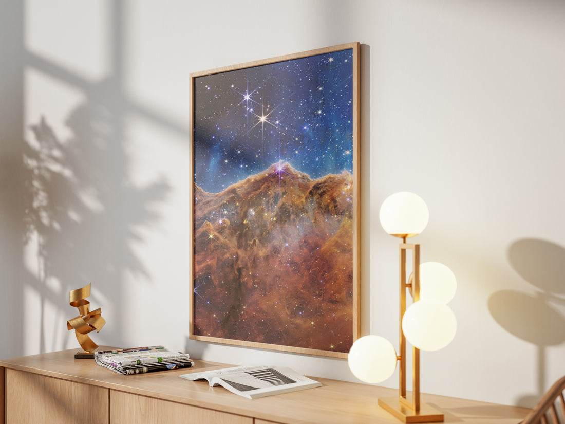 Framed Cosmic Cliffs print by Skylit Studio on a sideboard in a bright living room