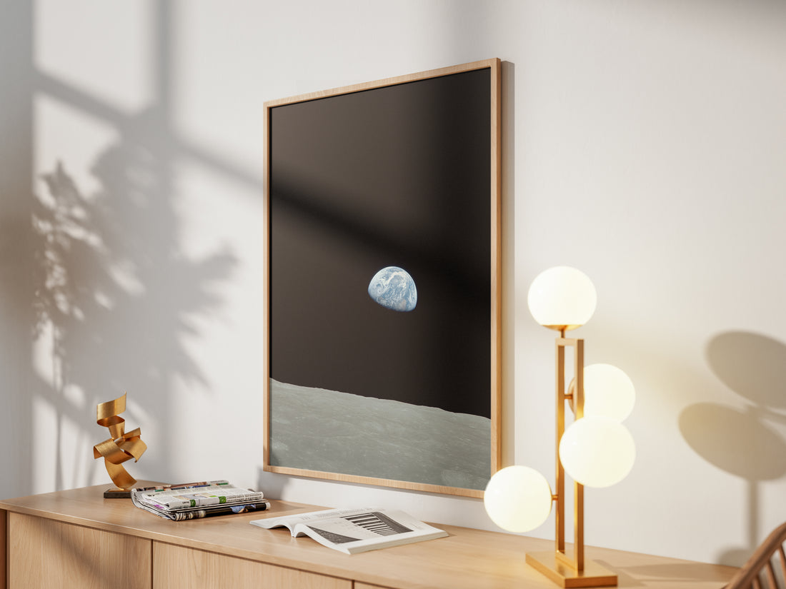 Framed Earthrise print by Skylit Studio on a sideboard in a bright living room
