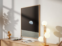 Framed Earthrise print by Skylit Studio on a sideboard in a bright living room