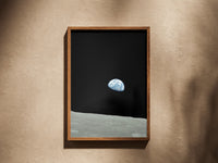 Earthrise print in a wooden frame on a plaster wall