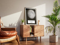 Boxed moon map in a black frame on a wooden dresser