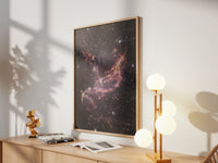 Framed NGC 346 print by Skylit Studio on a sideboard in a bright living room