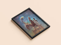 Pillars of Creation (Hubble) print in a black frame, flat lay