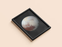Pluto print in a black frame, flat lay