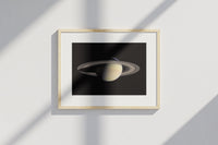 Framed Saturn print by Skylit Studio on a sideboard in a bright living room