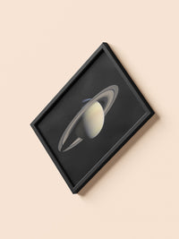 Saturn print in a black frame, flat lay