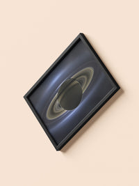 Saturn print in a black frame, flat lay