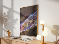 Framed Veil Nebula print by Skylit Studio on a sideboard in a bright living room