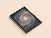 Whirlpool Galaxy print in a black frame, flat lay