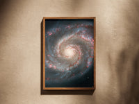 Whirlpool Galaxy print in a wooden frame on a plaster wall